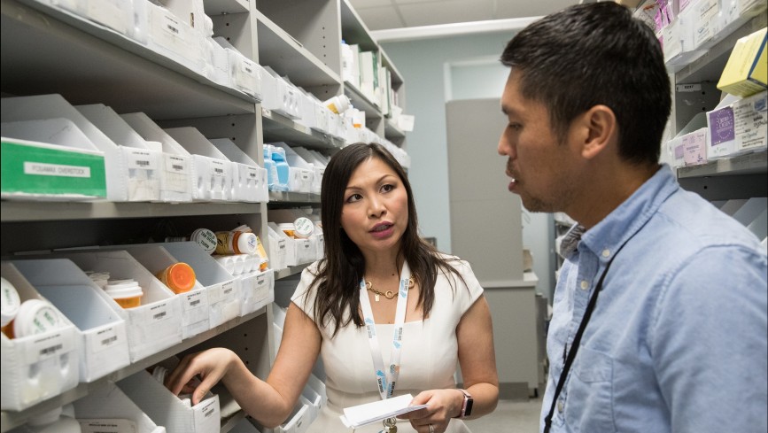 Two employees in a pharmacy supply room 