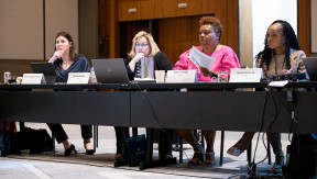 four women sitting at a long table